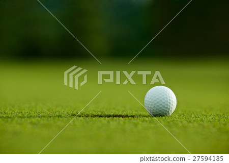 selective focus. white golf ball near hole on gree selective focus. white golf ball near hole on gree 27594185