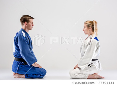 The two judokas fighters posing on gray The two judokas fighters posing on gray 27594433
