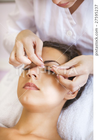 Make-up artist doing make up for young woman 27595237