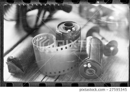Stylized photo: rolled up film, casette and camera 27595345