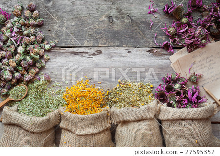 Healing herbs in bags on wooden table 27595352