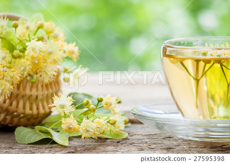 Cup of linden tea and wicker basket with lime flowers, herbal me 27595398
