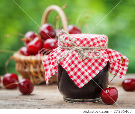 Jars of jam and basket with cherry on background. 27595403