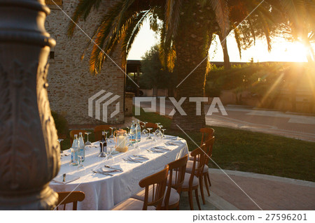 Sunset illuminates round dinner table  27596201