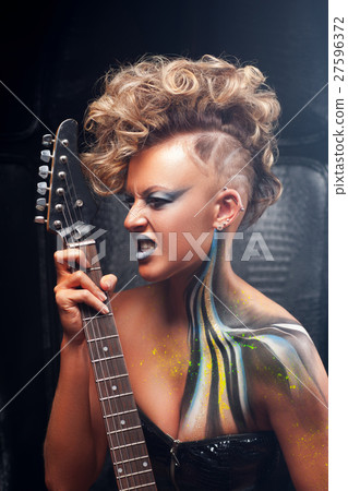 Impressed punk musician playing on guitar Impressed punk musician playing on guitar 27596372