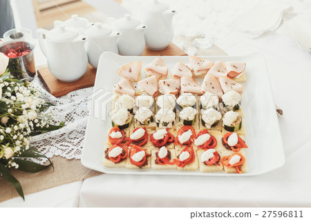 Tasty appetizers of fish and vegetables served  27596811