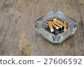 A dirty ashtray with cigarette ash and butts 27606592