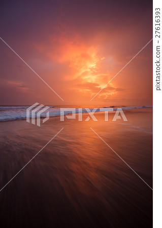 Sunset clouds and waves on empty beach 27616393