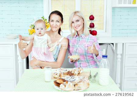 Pretty woman in the kitchen with the baby. 27619562
