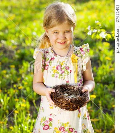 Little girl holding an Easter eggs in the nest Little girl holding an Easter eggs in the nest 27621492