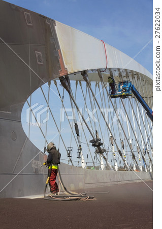 Man with helmet working on a bridge construction Man with helmet working on a bridge construction 27622034