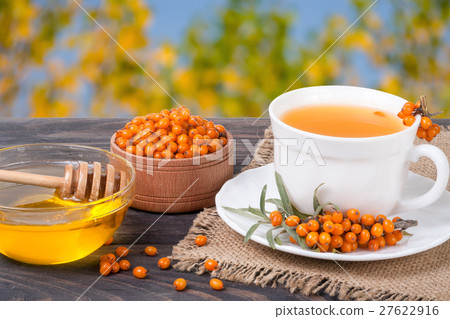 Tea of sea-buckthorn berries with honey on wooden 27622916