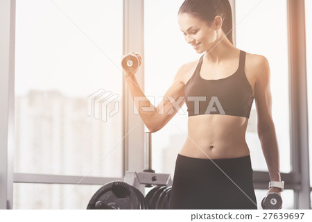 Active woman using dumbbells while training 27639697