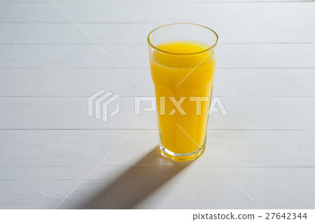 glass of juice on a table. glass of juice on a table. 27642344