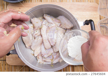 Chef putting flour to chicken wings for cooking 27645604