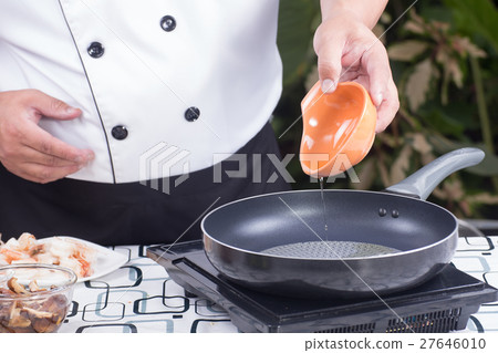 Chef pouring vegetable oil to the pan 27646010