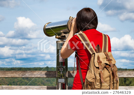 Young woman looking through tourist telescope Young woman looking through tourist telescope 27646329