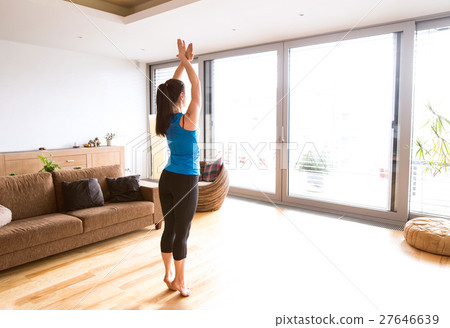 Young woman exercising at home, stretching legs 27646639