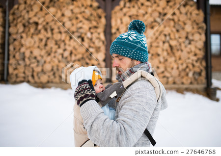 Father holding son in baby carrier. Winter nature. 27646768