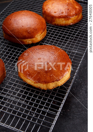 Tasty fresh newly-baked buns on a iron grid  27648005