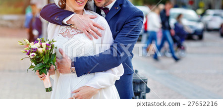 Wedding couple is hugging each other. bouquet in 27652216