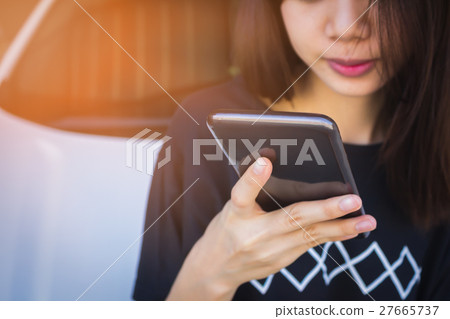 woman hand holding and using mobile on car  27665737