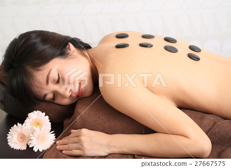 Women receiving hot stone massage Women receiving hot stone massage 27667575