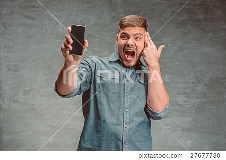 The young smiling caucasian businessman on gray 27677780