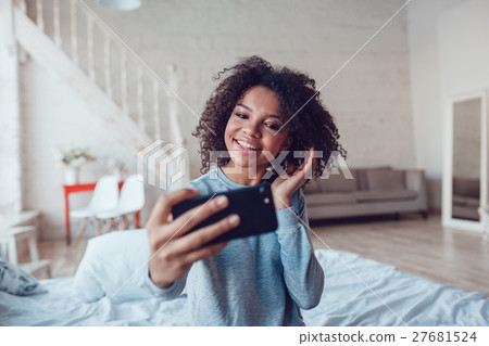 Pretty smiling african girl make selfie sitting on Pretty smiling african girl make selfie sitting on 27681524