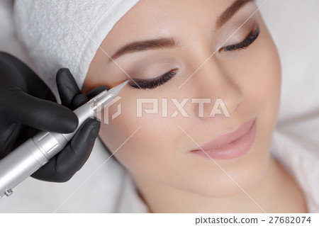 Cosmetologist making permanent make up at beauty Cosmetologist making permanent make up at beauty 27682074