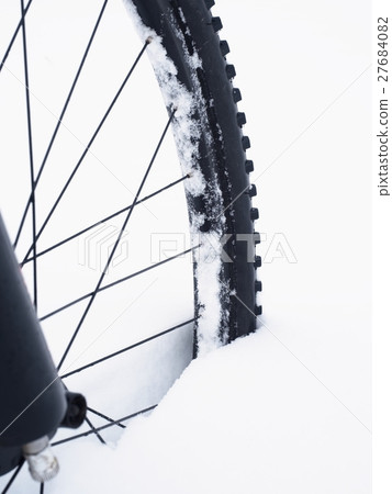 The front wheel of mountain bike in powder snow. 27684082