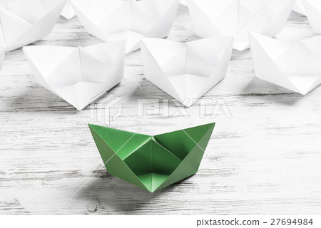Business leadership concept with white and color paper boats on wooden table Business leadership concept with white and color paper boats on wooden table 27694984