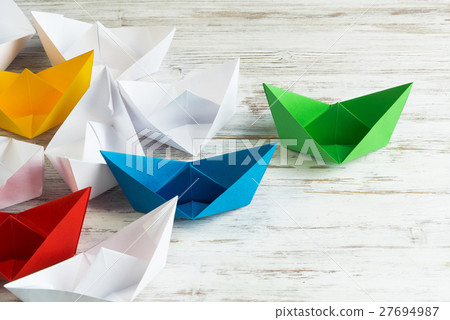 Business leadership concept with white and color paper boats on wooden table 27694987