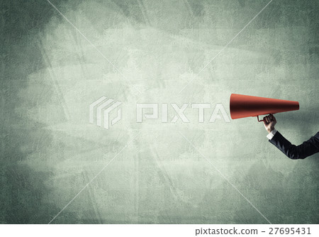 Hand of businesswoman holding red paper trumpet against concrete background Hand of businesswoman holding red paper trumpet against concrete background 27695431