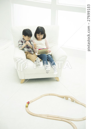 Brothers using tablet PC on sofa Brothers using tablet PC on sofa 27699183