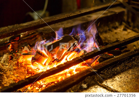 Ignite the coals on the grill for cooking BBQ. 27701356