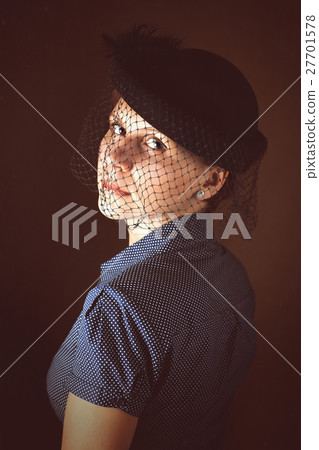 Portrait of sad woman in hat with veil on funeral. 27701578