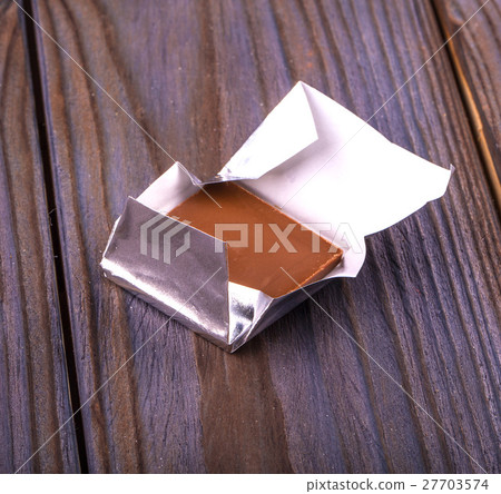chocolates wrappedon wooden table 27703574