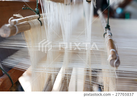 Close up loom with white yarn 27703837