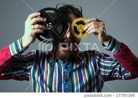 Bearded man with two 16mm film reel Bearded man with two 16mm film reel 27705160