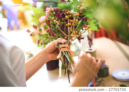 Saleswoman rolling by tape bouquet 27705730