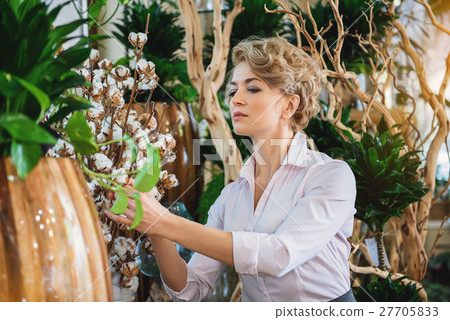 Skillful woman taking care of goods in flower shop Skillful woman taking care of goods in flower shop 27705833