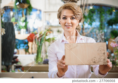 Cheerful flower shop owner presenting goods Cheerful flower shop owner presenting goods 27706008