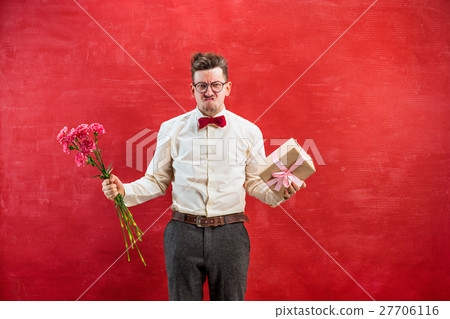 Young funny man with flowers and gift 27706116