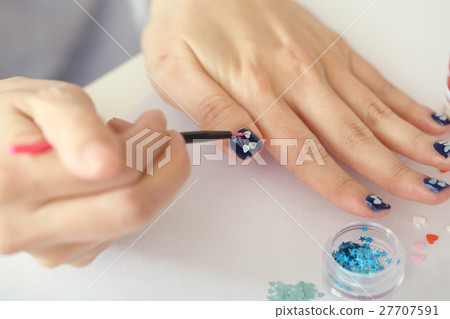 A woman who is nailing A woman who is nailing 27707591