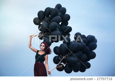 Beautiful girl walking with black balloons 27707718