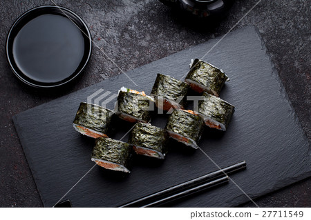 Sushi roll on a stone plate and dark concrete Sushi roll on a stone plate and dark concrete 27711549
