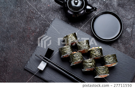 Sushi roll on a stone plate and dark concrete Sushi roll on a stone plate and dark concrete 27711550