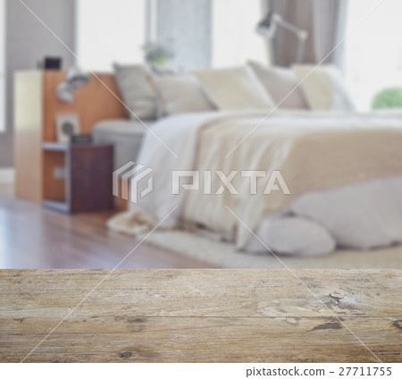 wooden table top with blur of modern bedroom 27711755