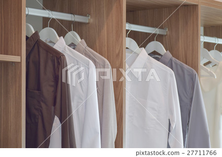 Classic color shirts hanging in wooden wardrobe 27711766